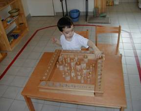 Montessori student playing with various weights.